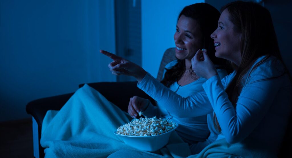two women watching a movie featuring chocolate