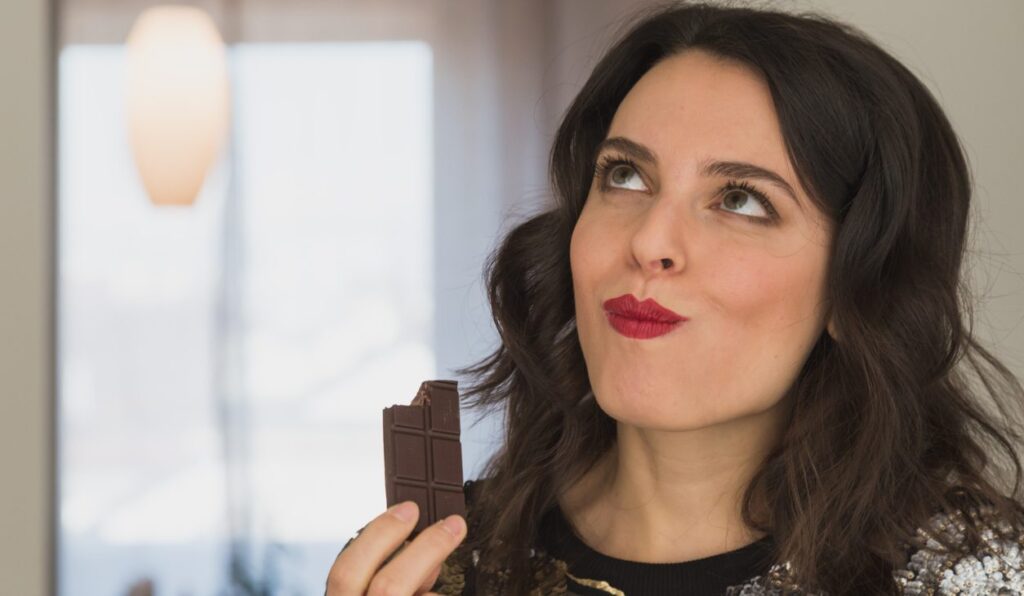woman enjoying health benefits - and taste! - of dark chocolate