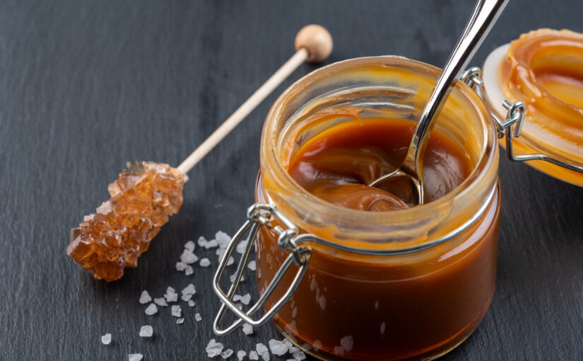 Rock candy swizzle stick and jar of homemade caramel sauce