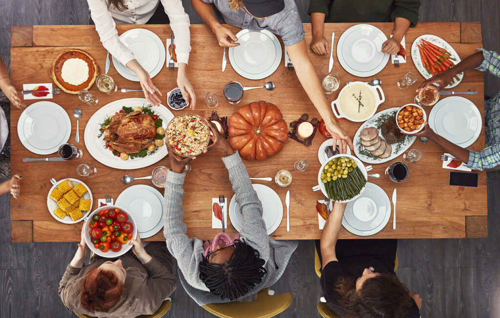 Overhead shot of a multiracial group of people sitting together at the Thanksgiving table