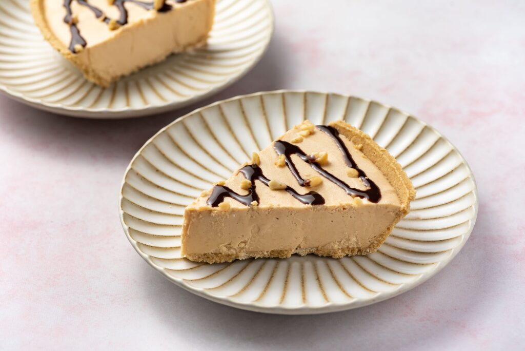 slice of peanut butter pie with peanuts and chocolate drizzle